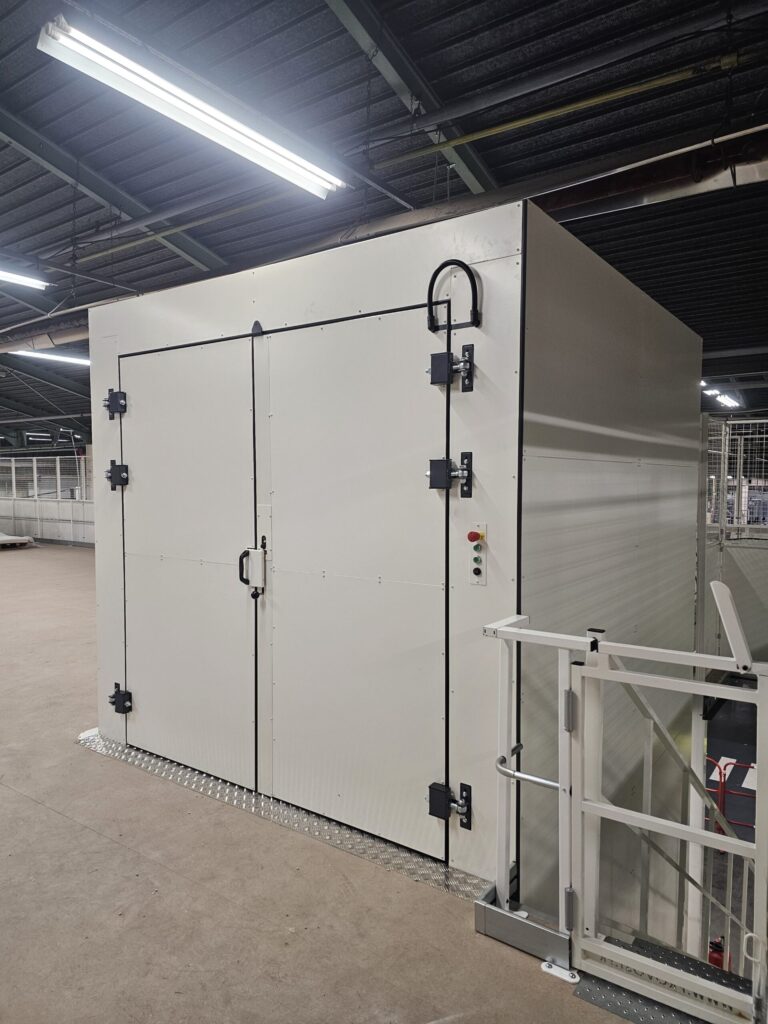 Monte-charge industriel Kintis installé sur une mezzanine d’atelier, avec portillon de sécurité